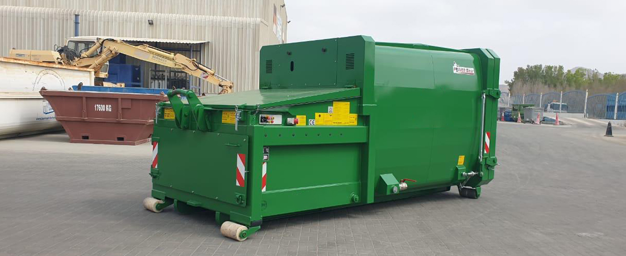 A large, green, compact trash bin with the POWER Bear branding. The bin is designed for efficient waste compaction and management.